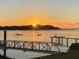 zwei Boote auf dem Wasser an einem Dock bei Sonnenuntergang in der Unterkunft Peaceful River Front Escape Short walk to Ocean St in Maroochydore
