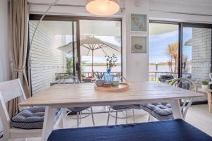 a dining room with a wooden table and chairs at Peaceful River Front Escape Short walk to Ocean St in Maroochydore