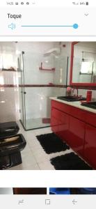 a bathroom with a red sink and a mirror at apto centro de gramado in Gramado