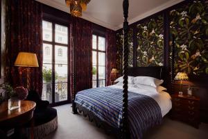 a bedroom with a canopy bed and a room with windows at The Portobello Hotel in London