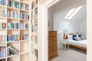a bedroom with book shelves filled with books at Independence House in Oakham