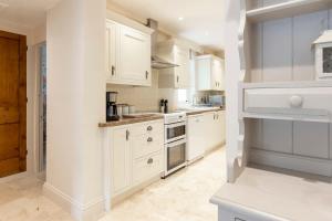 a white kitchen with white cabinets and appliances at Independence House in Oakham