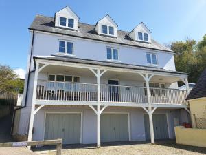 a white house with a balcony and garage at Golygfa Mor Tresaith 