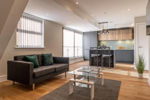 a living room with a couch and a table at Bond House by Celador Apartments in Reading