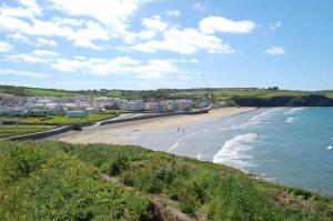 a beach with people walking on the sand and the water at Rockfield Broad Haven in Broad Haven