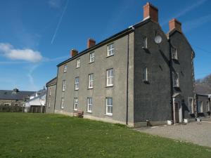 a large gray building with a grass field in front of it at St Brides View Solva in Solva