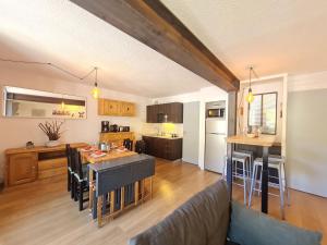 eine Küche und ein Wohnzimmer mit einem Sofa und einem Tisch in der Unterkunft Andromede - 90 - Appart renove 6 pers in Les Deux Alpes