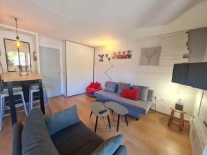 ein Wohnzimmer mit einem blauen Sofa und roten Kissen in der Unterkunft Andromede - 90 - Appart renove 6 pers in Les Deux Alpes