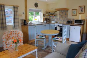 a kitchen with a table and a table and chairs at The Hideaway Brongest in Troedyraur
