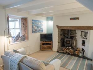 a living room with a couch and a fireplace at Driftwood Cottage Llangrannog in Llangranog
