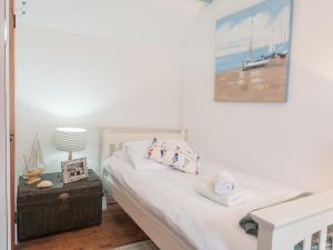 a bedroom with a bed with a picture on the wall at Driftwood Cottage Llangrannog in Llangranog