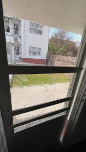 una ventana en una puerta con vistas a un edificio en Pasaje 202 en Aldea Camarero