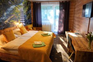 1 dormitorio con 1 cama con toallas verdes en Hotel Raj, en Dedinky