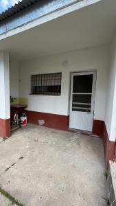 un garaje con una puerta blanca y una ventana en Pasaje 202 en Aldea Camarero