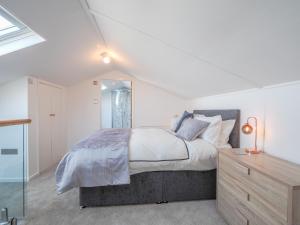 a bedroom with a large bed and a mirror at Hiraul Aberporth in Aberporth