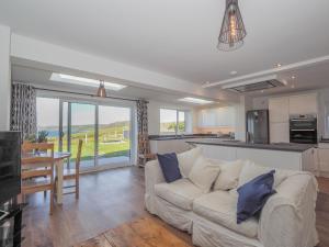 a living room with a couch and a kitchen at Hiraul Aberporth in Aberporth