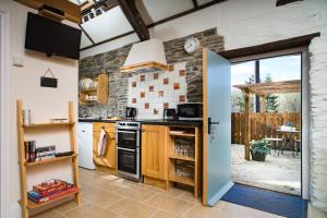 a kitchen with an open door leading to a patio at The Old Stables Brongest in Troedyraur