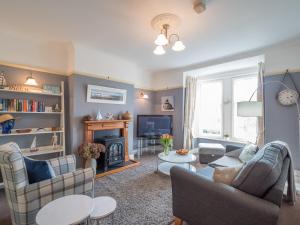 a living room with two couches and a fireplace at Clydfan Apartment Aberporth in Aberporth