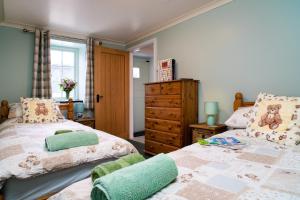 a bedroom with two beds and a dresser at Bwthyn Briallen Crymych in Crymmych Arms