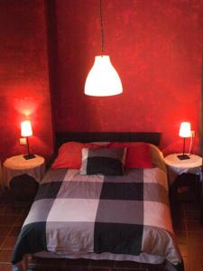 una camera da letto con pareti rosse e un letto con due lampade di Apartamentos Sol Valdelinares a Valdelinares