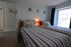 a bedroom with two beds and a window at Orielton Newport in Dinas