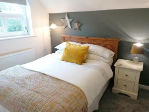 a bedroom with a bed with a yellow pillow on it at Manchester House Narberth in Lampeter-Velfrey