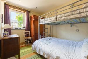 a bedroom with a bunk bed and a desk at The Stables Newgale in Llandeloy