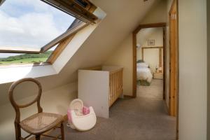 a small attic room with a window and a chair at Cnwc Y Bran St Nicholas in Saint Nicholas