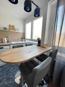 eine Küche mit einem Holztisch und Stühlen in der Unterkunft Appartement chic Choisy-le-Roi in Choisy-le-Roi