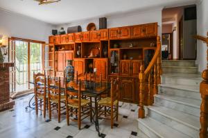 a dining room with a table and some wooden cabinets at Villa Maria By Solymar Holiday in Alhaurín de la Torre