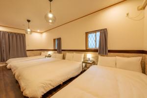 twee bedden in een kamer met twee ramen bij New Open 天神橋筋六丁目駅徒歩1分 バーカウンター付き一軒家 天満居酒屋街徒歩3分 梅田 難波10分 in Osaka