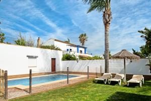 uma villa com uma piscina e uma palmeira em Casa Ale em Cádiz