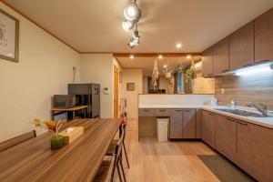 een keuken met een houten tafel en een aanrechtblad bij New Open 天神橋筋六丁目駅徒歩1分 バーカウンター付き一軒家 天満居酒屋街徒歩3分 梅田 難波10分 in Osaka