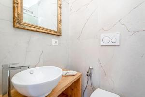 uma casa de banho com um lavatório branco e um espelho. em Giglio em Volastra