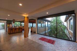 a living room with a large glass window and a kitchen at Utopia Casas Boutique in Oaxaca City