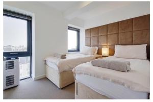 ein Hotelzimmer mit 2 Betten und einem Fenster in der Unterkunft Beach Penthouse Apartment Bournemouth in Bournemouth