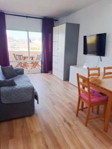 een woonkamer met een bank en een tafel bij BENALBEACH RESORT NEW APARTMENT - Benalmádena Málaga in Benalmádena