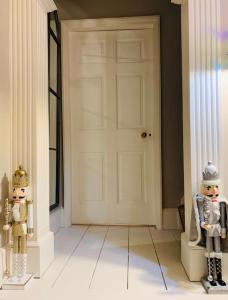 two figurines standing in front of a white door at Stylish Georgian Townhouse, Yorkshire - sleeps 12 in Easingwold