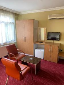 een hotelkamer met een woonkamer met stoelen en een televisie bij Mina 1 Hotel in Ankara