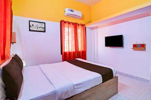 a bedroom with a bed and a television in it at OYO Home Modern Stay Near Iter in Khandagiri