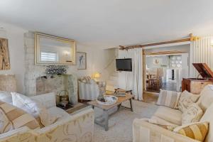 a living room with two white couches and a fireplace at North End House - Batheaston in Bath