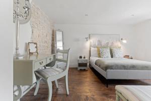 a bedroom with a bed and a desk and a chair at North End House - Batheaston in Bath