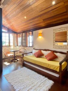 a bedroom with a bed and a table with chairs at Pousada Morro do Forte in Paraty