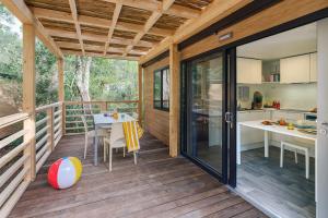 a screened in porch with a table and a kitchen at PuntAla Camp & Resort in Punta Ala