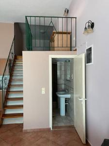 La salle de bains est pourvue d'un lavabo, de toilettes et d'un escalier. dans l'établissement Μεζονέτα Τοξότης, à Chios