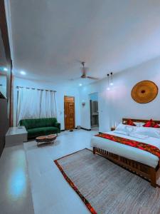 Dream Stay Lodge and Restaurant في دودوما: غرفة نوم بسرير كبير واريكة خضراء