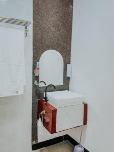bagno con lavandino bianco e specchio di Dream Stay Lodge and Restaurant a Dodoma