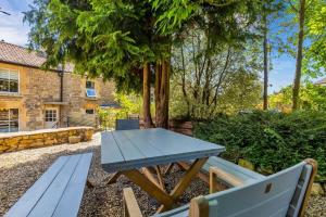 a picnic table and benches in the garden of a cottage at North End House and Seven Acres Cottage in Batheaston