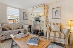 a living room with a couch and a fireplace at North End House and Seven Acres Cottage in Batheaston