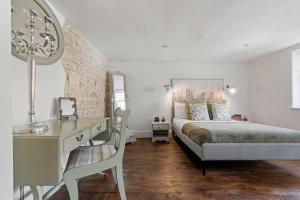 a bedroom with a bed and a desk with a chair at North End House and Seven Acres Cottage in Batheaston